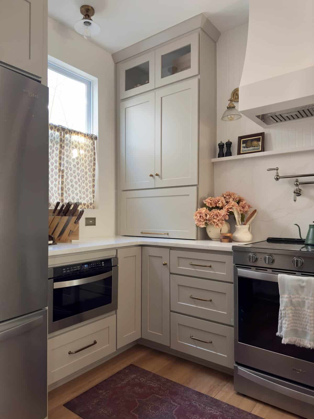 taupe kitchen with countertop cabinets for appliance garages and quartz slab backsplash